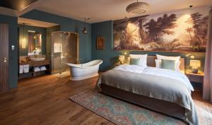 格林德Vabali Spa Hamburg Hotel的一间带大床和浴缸的卧室以及一间浴室