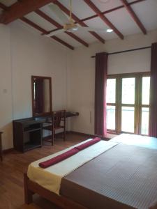 康提Villa 95 Rangala的一间卧室配有一张床、一张书桌和窗户。