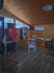 TaipalsaariMökki ja rantasauna Saimaan rannalla的配有桌椅和视频游戏的房间
