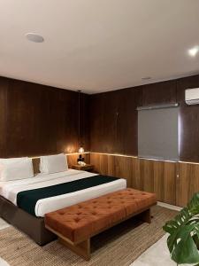拉各斯The Borough Lagos的一间卧室配有一张大床和一张棕色的沙发