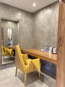 拉各斯The Borough Lagos的用餐室配有黄色椅子和桌子