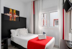 马拉加画家酒店的酒店客房配有一张带红色毯子的白色床