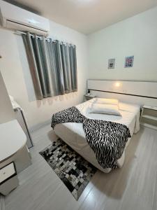 卡内拉Pousada Cinnamon的一间卧室配有一张带黑白毯子的床