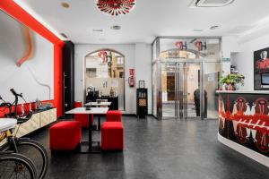 马拉加画家酒店的餐厅拥有红色调,配有桌椅