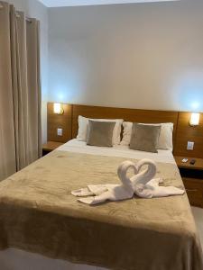 塞古罗港Hotel Portal do Descobrimento的酒店客房的床上配有2条天鹅绒毛巾