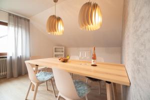HolzmadenFerienwohnung Fischer的一间带木桌和两个灯的用餐室