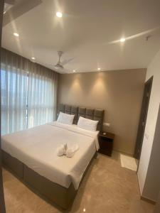 孟买Maxxvalue Apartment Hiranandani Powai - RH5的一间卧室配有一张带白色鞋的大床