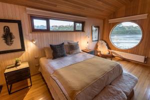 卡斯特鲁Bledford Chiloé的一间卧室设有一张床和一个大窗户