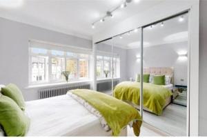 伦敦9 Brentwood Lodge的一间卧室配有两张带绿色棉被的床