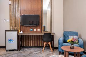 亚的斯亚贝巴South Gate Hotel Apartment的配有电视、椅子和桌子的房间
