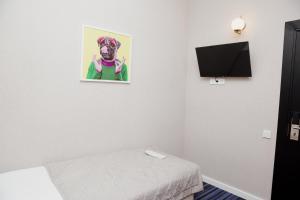 阿斯塔纳AMINA HOTEL的一间房间,配有一张床和一张狗的照片