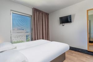 马赛B&B HOTEL Marseille Euromed的酒店客房设有床和窗户。