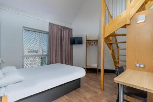 马赛B&B HOTEL Marseille Euromed的带床和楼梯的房间