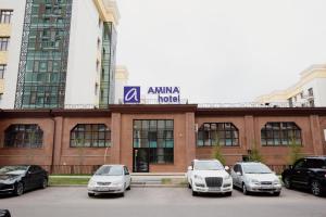 阿斯塔纳AMINA HOTEL的停在大楼前的一组汽车