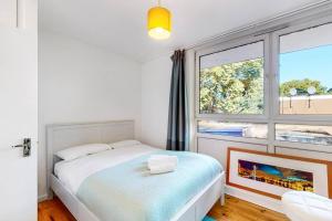 伦敦Charming 2-bedroom maisonette with private garden的一间卧室设有一张床和一个大窗户