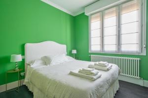 博洛尼亚Green House city center的绿色卧室,配有带毛巾的床