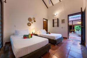 帕洛米诺La Mello Adventure Lodge的一间卧室设有两张床、一个窗口和一扇门