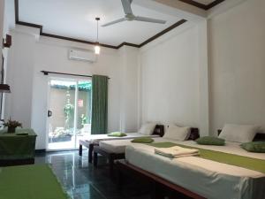 康提Kandy Forest Villa Hotel的绿色和白色的客房内的三张床