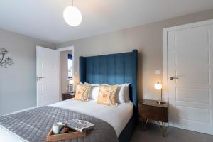 格洛斯特Elliot Oliver - Luxurious Two Bedroom Apartment With Parking的一间卧室配有一张大床和蓝色床头板