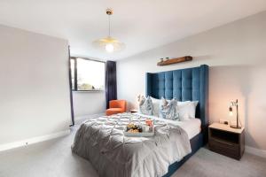 格洛斯特Elliot Oliver - Stunning Three Bedroom Penthouse With Large Terrace & Parking的一间卧室配有一张大床和蓝色床头板
