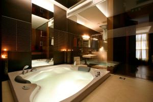 PerafitaMotel Flamingo的大型浴室设有大浴缸和大镜子
