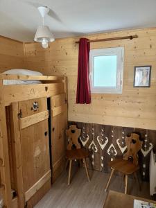 普雷芒翁Babaute 7, studio typique au pied des pistes的一间设有两把椅子、一张床和窗户的房间