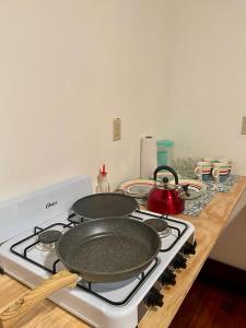 罗阿坦Rosa - Private room in shared house的炉灶,上面有两个平底锅