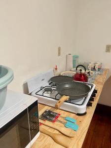 罗阿坦Rosa - Private room in shared house的厨房柜台配有带平底锅的炉灶