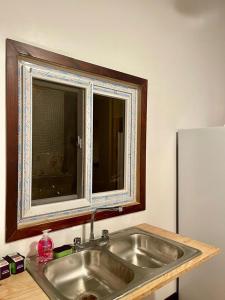 罗阿坦Rosa - Private room in shared house的厨房水槽和上面的窗户