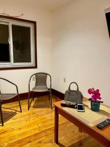 罗阿坦Rosa - Private room in shared house的客厅配有椅子和一张桌子,上面装有钱包