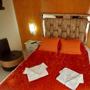 萨兰托玛塔托里马旅馆的一间卧室配有红色的床和两条白色毛巾