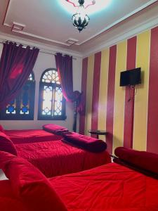 舍夫沙万塞维利亚酒店的一间卧室设有两张带红色床单和条纹墙的床。