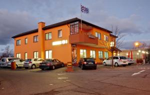 莱茵河畔威尔Hotel Ganita Weil am Rhein的一座橙色的建筑,汽车停在停车场