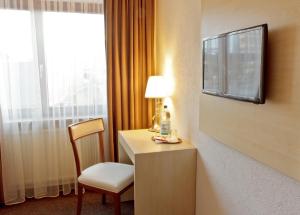 莱茵河畔威尔Hotel Ganita Weil am Rhein的酒店客房设有书桌和窗户。