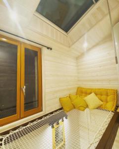圣艾尼昂La Tiny Blue - maison insolite pour 2 - sans Tv的窗户房间里一张黄色的沙发