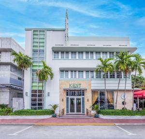迈阿密海滩肯特酒店的一座白色的建筑,前面有棕榈树