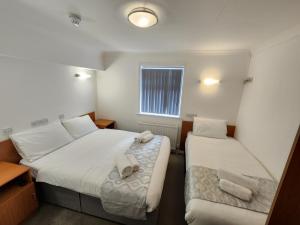 海斯SK Heathrow Hotel的小客房内的两张床和毛巾