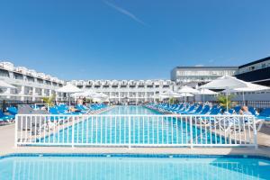 五月岬郡开普梅大酒店的一个带蓝色椅子和遮阳伞的大型游泳池