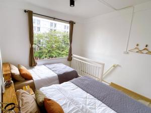 曼谷Lively and cozy canal house ,Entire house的一间卧室设有两张床和窗户。