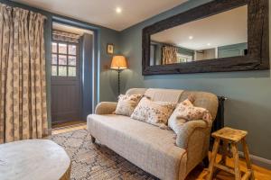 PeasenhallTipple Cottage的带沙发和镜子的客厅