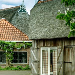RottevalleTeades Plak bij De Herberg van Smallingerland的一座带门和屋顶的旧谷仓