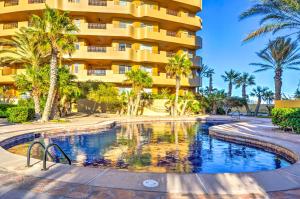 佩尼亚斯科港Oceanfront Puerto Peñasco Villa in Luxury Resort!的棕榈树酒店前的游泳池