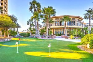 佩尼亚斯科港Oceanfront Puerto Peñasco Villa in Luxury Resort!的一座棕榈树高尔夫球场和一座建筑
