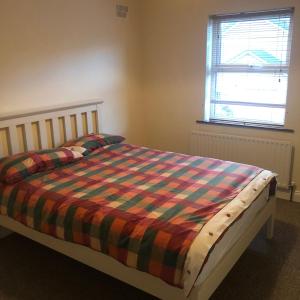Cluain EoisStunning 5-Bed House in Clones的一间卧室配有一张带彩色毯子的床