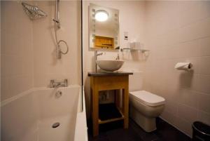 Kingsdon金斯洞旅馆的浴室配有盥洗盆、卫生间和浴缸。