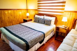 纳塔列斯港阿尔卡萨旅舍的一间卧室配有一张带2个床头柜的大床