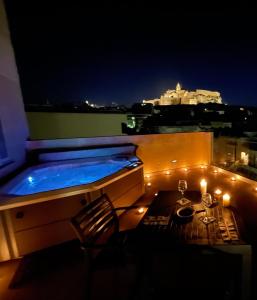 维多利亚Cittadella View Penthouse with Jacuzzi的一座大楼的顶部,晚上的热水浴池