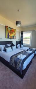 伊斯特布恩亚历山大酒店的卧室设有两张大床,卧室设有大窗户