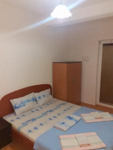 佩斯塔尼Apartmani BAKULE的一间卧室配有一张带蓝色床单的床和橱柜。