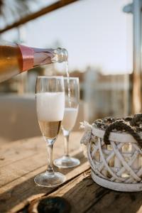 英格兰海滩Bungalows El Palmital - Adults Only的一瓶香槟倒入两杯酒杯